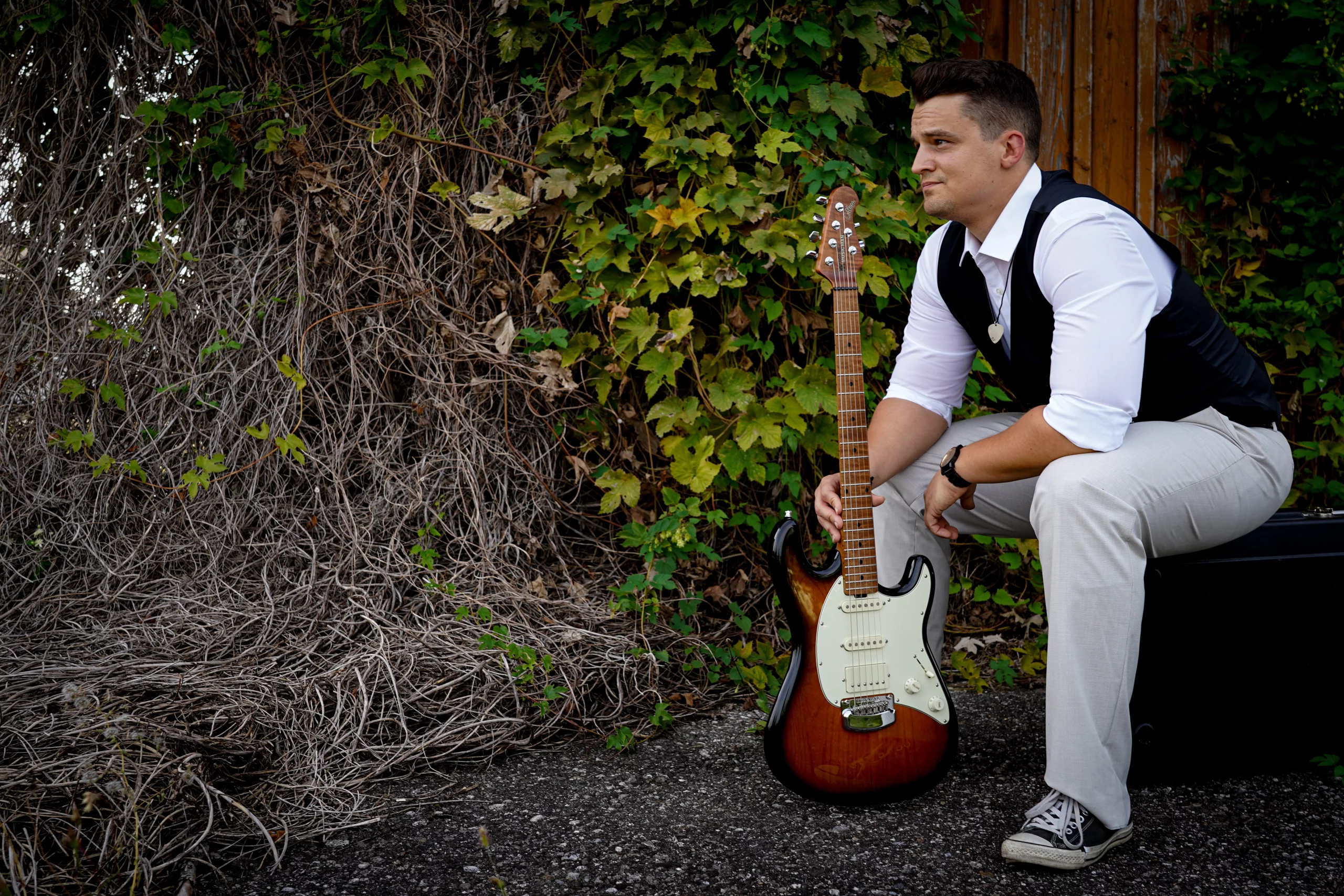 Bild zeigt David Schneider am Bahnhof mit seiner Gitarre.